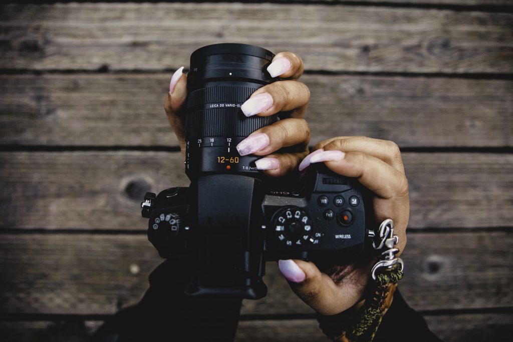 person holding black DSLR camera